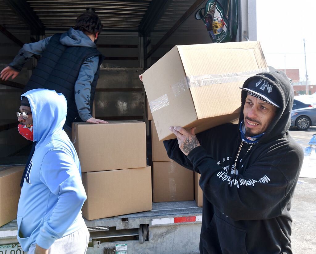 Lonnie Cooper and Rico Espinoza transfer boxes of food